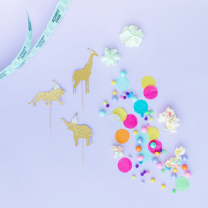 Flat lay of safari animal party cupcake toppers with hand made tissue confetti.
