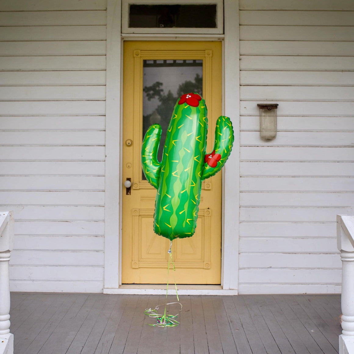 A 41 inch jumbo green cactus balloon with mini fiesta balloon garland.