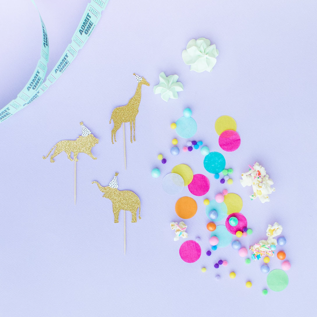 Flat lay of safari animal party cupcake toppers with hand made tissue confetti.