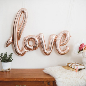 Rose gold cursive LOVE; balloon measuring approximately 40 inches.