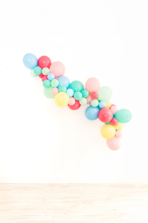 Another view of the balloon garland on the white wall with the following colors: pink, rose, pastel mint, pearl lemon, light blue, and aquamarine.