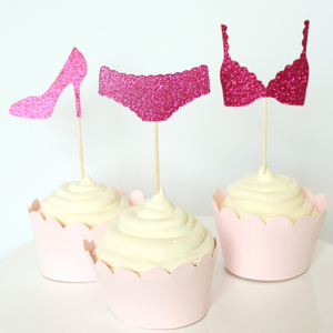Set of three pink glittery cupcake toppers. One is a pink glittery heel, one is a pink glittery underwear, and the other is a pink glittery bra.