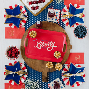 A red, white, and blue tablescape with red and white striped plates and blue star shaped plates.