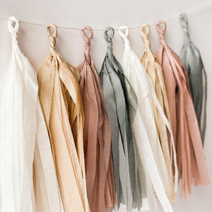 Eight hand rolled tassels hanging from a string used for a boho party theme.