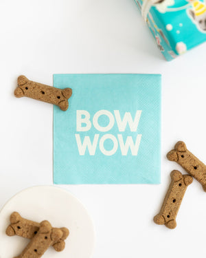 Light blue napkins with white words reading BOW WOW and dog treats around it.