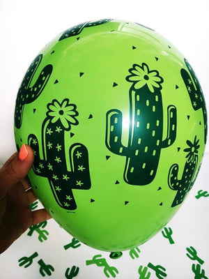A zoomed in view of the lime green balloon with green cactus design is shown with little green cactus confetti scattered in the background.
