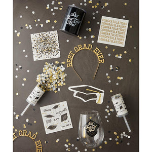 Graduation party flat lay with White napkins with gold CONGRATULATIONS word repeated seven times.