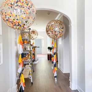 Hallway lined with construction theme clear jumbo confetti filled balloons with tassel tail
