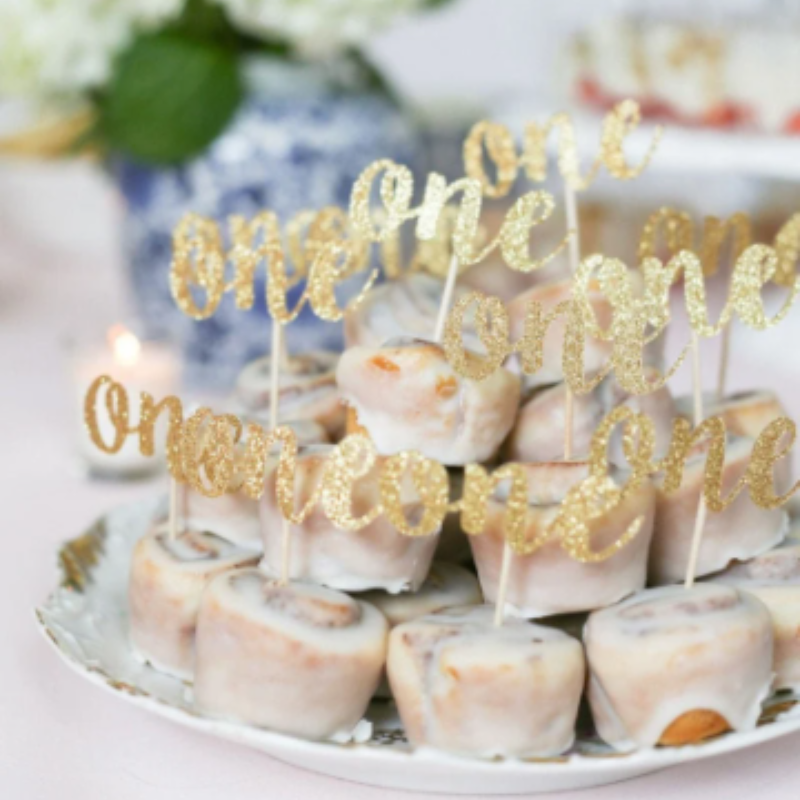 Glittery gold cursive ONE topper for cakes, cupcakes, and sweet treats.