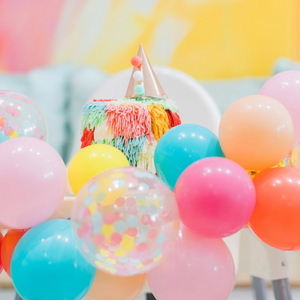 Close up of a DIY mini balloon garland on a kids high chair for a birthday celebration.