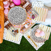 Black dot cream colored plates with pink macarons.