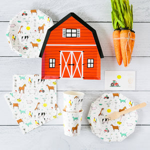 Red barn paper plate surrounded by white paper plates and cups with farm animals on it.