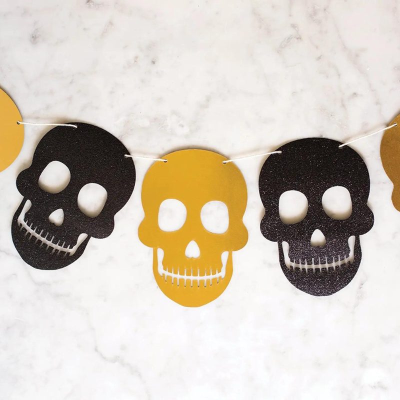 A photo of halloween skull banner with gold and black glittery skulls.