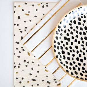 Black dot cream colored plates on top of matching paper napkins.