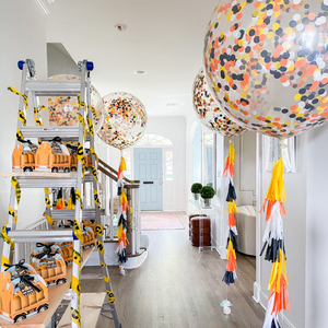Construction themed 3ft clear balloons stuffed with tissue confetti in the colors white, orange, black, and yellow with matching tassel tail.