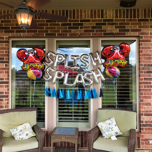 Silver balloon letters that spell SPLISH SPLASH in the middle of two giant red crabs and beach ball balloons.