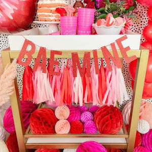 Valentines balloon decorations with pink and red balloons, tassels, jumbo lip balloon, and a BEA MINE red banner.