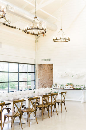 Close up of 20 foot white balloon garland with an assortment of 5 inch pearl white, white, and clear balloons sits as a centerpiece on a rustic wood table. Perfect for a bridal shower, wedding shower, boho baby shower, or wedding.