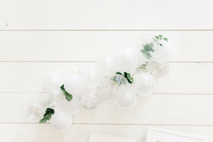 White mini balloon garland with an assortment of white, pearl white, and clear 5 inch balloons on a white background.
