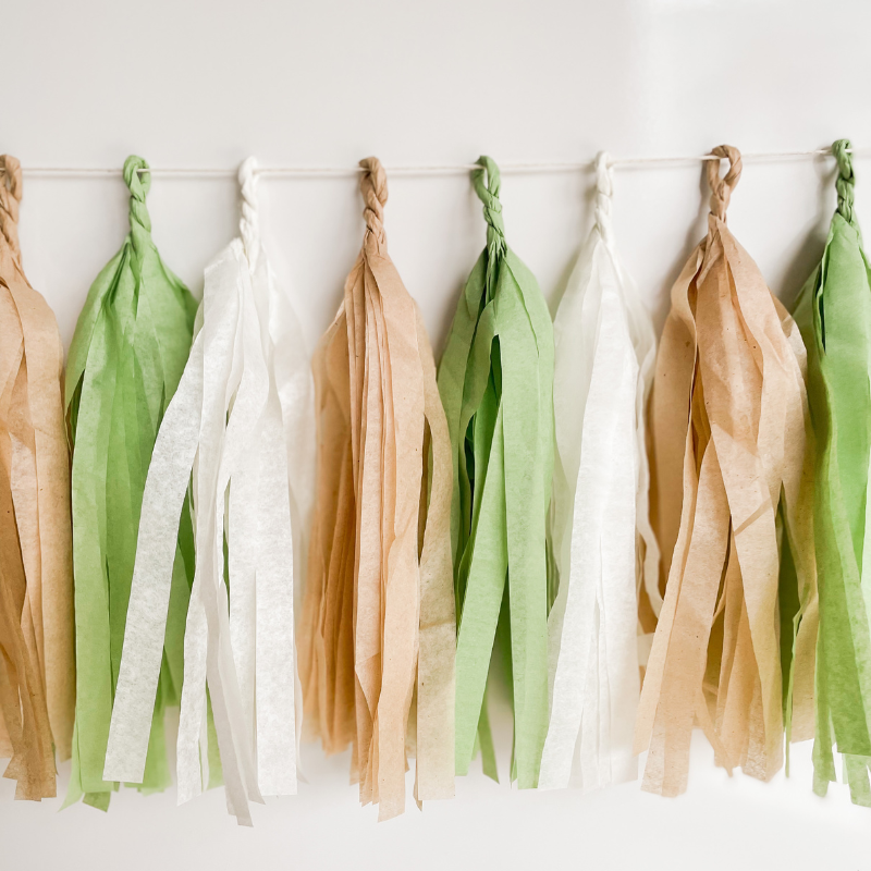 Set of 8 hand rolled Sage Boho Tassels on a white background.
