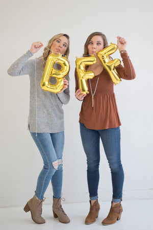 Two girls hold the banner higher in front of them while making silly faces.