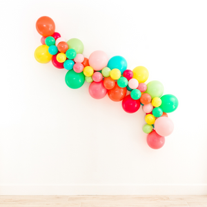 Balloon garland arch in the colors coral, wildberry, rose, pink, wintergreen, lime, caribbean blue, and yellow.