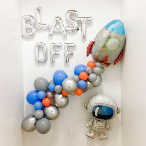 Rocket Ship Space Balloon party decorations on a white wall.