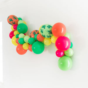 A side view of the garland is shown on the white wall to help see the mix of all sizes of the balloons.