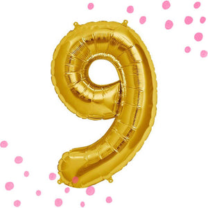 A gold colored number nine balloon inflated to show detail.