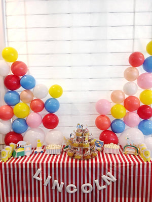 An assortment of 11 inch latex multi color balloons at a little boys birthday circus theme party.