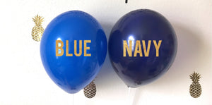One 11 inch latex blue balloon is hanging on a wall next to one 11 inch latex navy blue balloon.