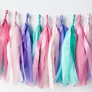 Angle view of hand rolled tissue tassel garland in the colors pink, blush, lilac, and aqua used in mermaid or princess inspired birthday girl parties, unicorn parties or baby showers.