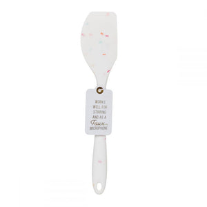 A silicone white confetti spatulas with a cute saying WORKS WELL FOR STIRRING AND A FAUX MICROPHONE.