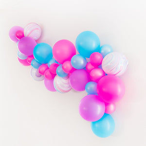 A fun and vibrant neon themed garland is stretched across a white wall. The colors shown are neon magenta, neon blue, neon purple, and marble print balloons.
