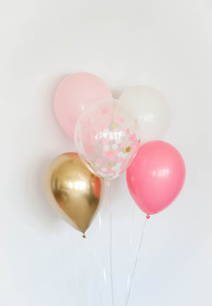 A princess balloon bundle with one pink, one rose, one white, one chrome gold, and one confetti filled balloon in front of a white wall. Can be used in a princess party, pink girl decor, or bachelorette party.