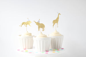Gold cupcake toppers on cupcakes with white frosting.