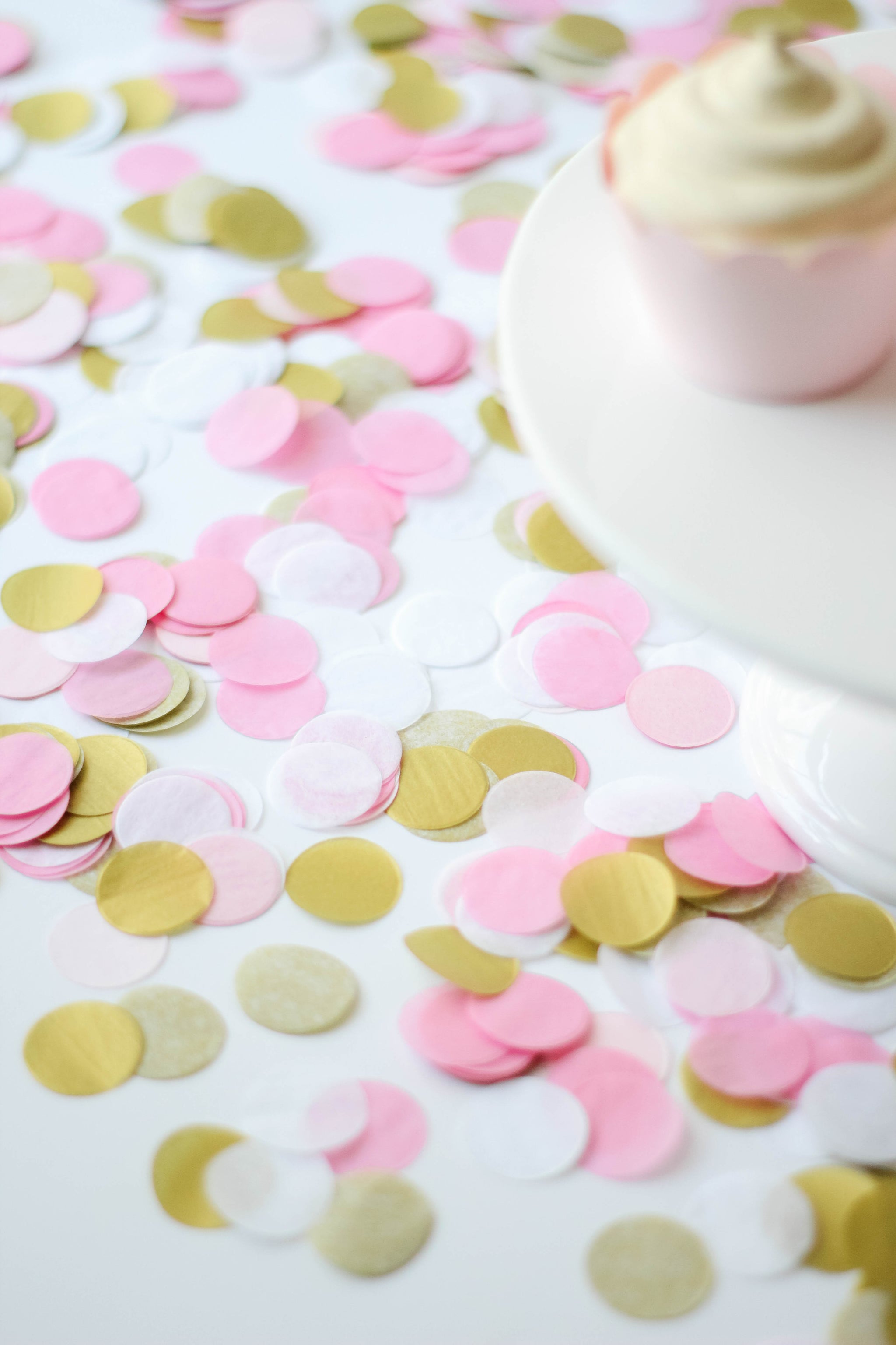 Close up of a pile of 1 inch handcut confetti circles in the colors pink, blush, white, and gold used in party celebrations, bachelorette, princess party, or girls birthday.