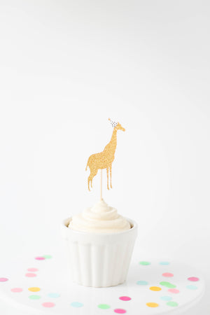 Gold zoo giraffe cupcake topper with mini party hat on top of a white cupcake.