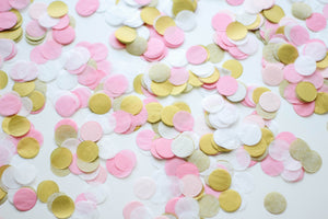 Close up of a pile of 1 inch handcut confetti circles in the colors pink, blush, white, and gold used in party celebrations.